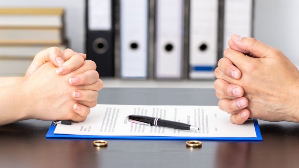 hands clasped on either side of signing a document